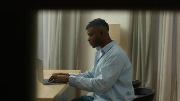 POV spy point of view African American man guy male user freelancer student business man working business late night evening at home thinking pensive typing laptop think solving problem author work photo