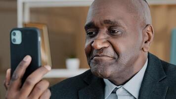 Closeup male portrait African American 50s old middle-aged businessman emotional professional man online remote conversation manager worker looking in mobile phone camera talking conference call photo