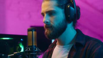 Addict Caucasian man guy streamer vlogger putting on headphones male gamer blogger prepare for stream radio broadcast influencer player talking communicate microphone mic at home play online game vlog photo