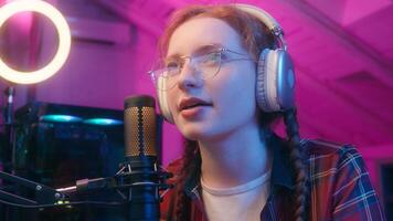 Close up Caucasian woman girl streamer gamer cyber gaming addiction female blogger influencer programmer coder look computer play game record radio podcast headphones online stream neon studio photo