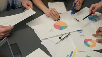 Top view hands and documents on table unknown group business men women team coworkers planning work data graphs charts papers analysis project analyze paperwork corporate teamwork brainstorm at office photo