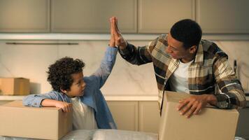 African American ethnic happy family father son moving in new own apartment buy rent house happy male home owners dad little kid boy child giving high five hand gesture teamwork celebrate relocation photo