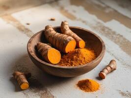 Turmeric roots and powder in wooden bowl on textured surface with scattered roots in natural light photo