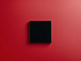 Black Square Object on Vibrant Red Background for Dynamic Visuals photo