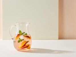 Peach iced tea in pitcher with refreshing mood on light background photo