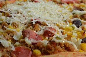 Delicious pizza with topping sausages, cheese, and corn, delicious meal to eat photo