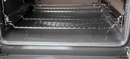 Modern electric oven with a grate on telescopic rails. Close-up photo