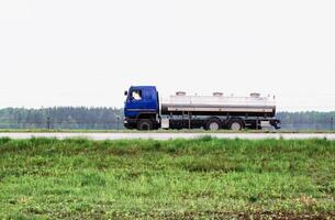 Truck milk tanker transports milk on the highway. Farming, copy space for text. Industry photo