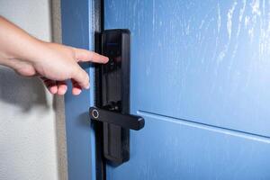 A man opens a door with an electronic lock using an access password. Modern electronic reliable locks for entrance doors. Copy space for text photo