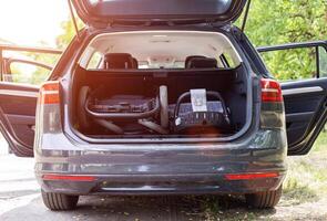 transporting a baby stroller in the trunk of a car when folded, close-up photo
