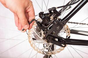 Unscrewing the bicycle brake caliper to change the brake pads and adjust the brakes. Copy space for text photo