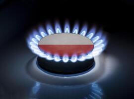 Burning gas burner of a home stove in the middle of which is the flag of the country of Poland. Gas import and export delivery concept, price per cubic meter, transit, background photo