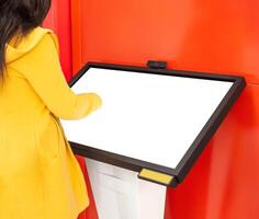 The girl clicks on the touch screen of the information assistant and help in the bank, copy space. Place for text. Modern technologies photo