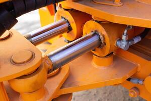 Powerful hydraulic pumps that stand in the bucket of an excavator, industry, close-up, orange photo