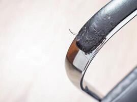 Torn and battered leather on a black office computer chair. Restoration and restoration of the leather, copy space photo