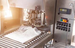 The automatic process of making confectionery food cream for adding to cakes and sweet products, desserts. Packing ultra-pasteurized cream in bags, milk cream photo