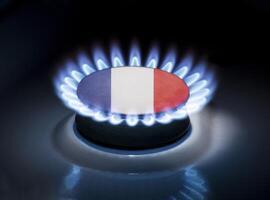 Burning gas burner of a home stove in the middle of which is the flag of the country of France. Gas import and export delivery concept, price per cubic meter, transit, background photo