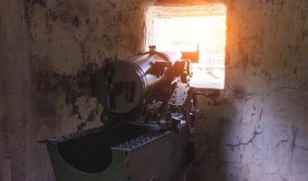 A military gun installed in a defensive artillery point of a pillbox. Protecting the fortress from attack in wartime, close-up photo