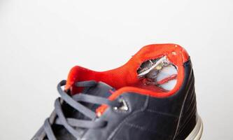 Torn backs in multicolored sports sneakers on a white background, isolate. Poor quality shoes. Copy space for text, macro photo