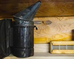 smoker for bees on a wooden background. Breeding bees and extracting honey. Copy space for text photo