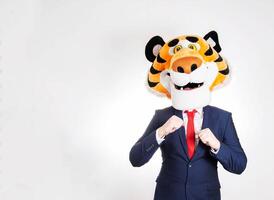 Dancing man in a business suit and a tiger mask on his head on a white background, humor. Copy space for text photo