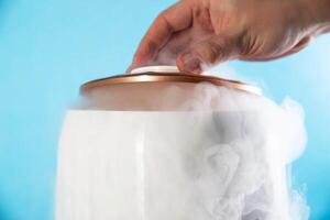 A man opens the lid from a humidifier on a blue background. Close-up. Creating a comfortable room temperature, close-up photo