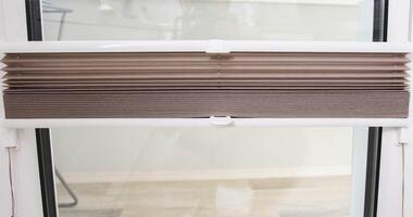 Modern classic aluminum blinds on the window sash with a scaffold fixing system. Protection from prying eyes and the sun. photo