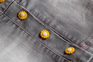 Stylish buttons on a trendy denim skirt, background, macro. photo