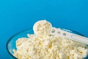 Measuring spoon in a plate with dry baby food for preparing infant formula. Enriched with bifidobacteria, minerals and vitamins, macro, Copy space for text photo