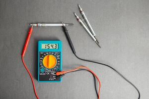 Checking the serviceability of the glow plug with a multimeter. Glow plug voltage resistance. Modern heating element, close-up photo