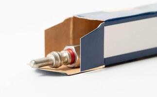 New modern ceramic glow plugs in packaging on a white background. Concept for replacing glow plugs in cold weather, close-up. Automotive part photo