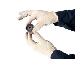 An auto mechanic holds and checks the timing belt idler on a white background, isolate. Faulty timing roller, industry photo