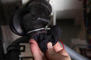 The rubber drain pipe and drain pump are clogged with clothes in the washing machine. Cleaning the water drain hole, industry photo