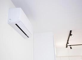 Modern wall-mounted air conditioner in the apartment with heating and cooling capacity of the room. Comfortable temperature. Copy space for text photo