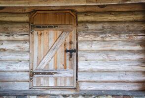 Old wooden door with a metal lock in a rustic log house, antique. Copy space for text photo