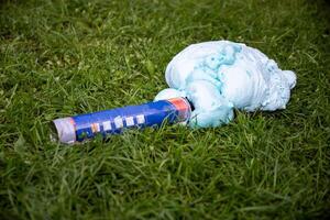 An exploded cylinder with construction foam on the grass. Balloon defect, close-up photo