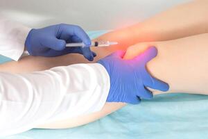The doctor makes an injection of platelet-rich plasma, autostimulation of the regenerative processes of the joints, close-up photo