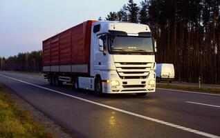 A beautiful truck with a trailer against the backdrop of an evening sunset before night. The concept of work and rest regime for truck drivers. Fine for breaching rules photo