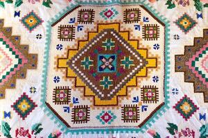 Traditional rustic tablecloth with handmade patterns and embroidery, macro photo