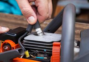 Removing the spark plug from the chainsaw cylinder. Replacing a new spark plug, a malfunction in the ignition of the fuel. Close-up photo