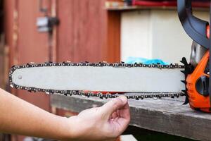 wear and tear of the chain on the chainsaw bar. Chain adjustment and tension. Copy space for text photo