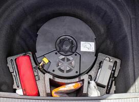 original subwoofer, first aid kit and compressor for inflating wheels in a car trunk niche photo