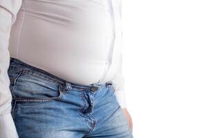 Fat man in a tight white shirt with a big belly. The concept of improper digestion of food, bloating in office workers photo