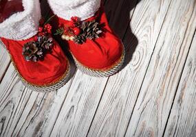 Red santa claus boots on a white wooden background. Handmade, new year 2022. Copy space for text photo