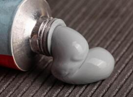 High quality automotive high temperature sealant. Gray universal one-component sealant, macro photo
