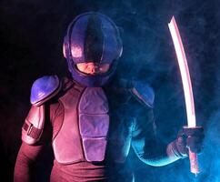 Cyberpunk future concept. Bionic cyborg police officer with short samurai sword stands in dark with smoke, fume. Halfman robot looks at camera. Futuristic science fiction scene. photo