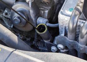 Oil dipstick in a diesel engine. Engine breakdown from low oil level, industry photo