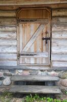 Old wooden door with a metal lock in a rustic log house, antique. Architecture photo