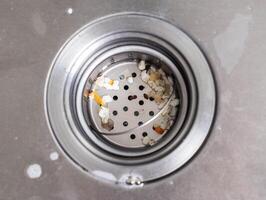 Filter mesh in the sink to clean the drain hole in the sink from particles of food, close-up photo