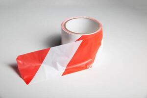 Red-white striped ribbon on a white background, isolate. Prohibition tape, close-up photo